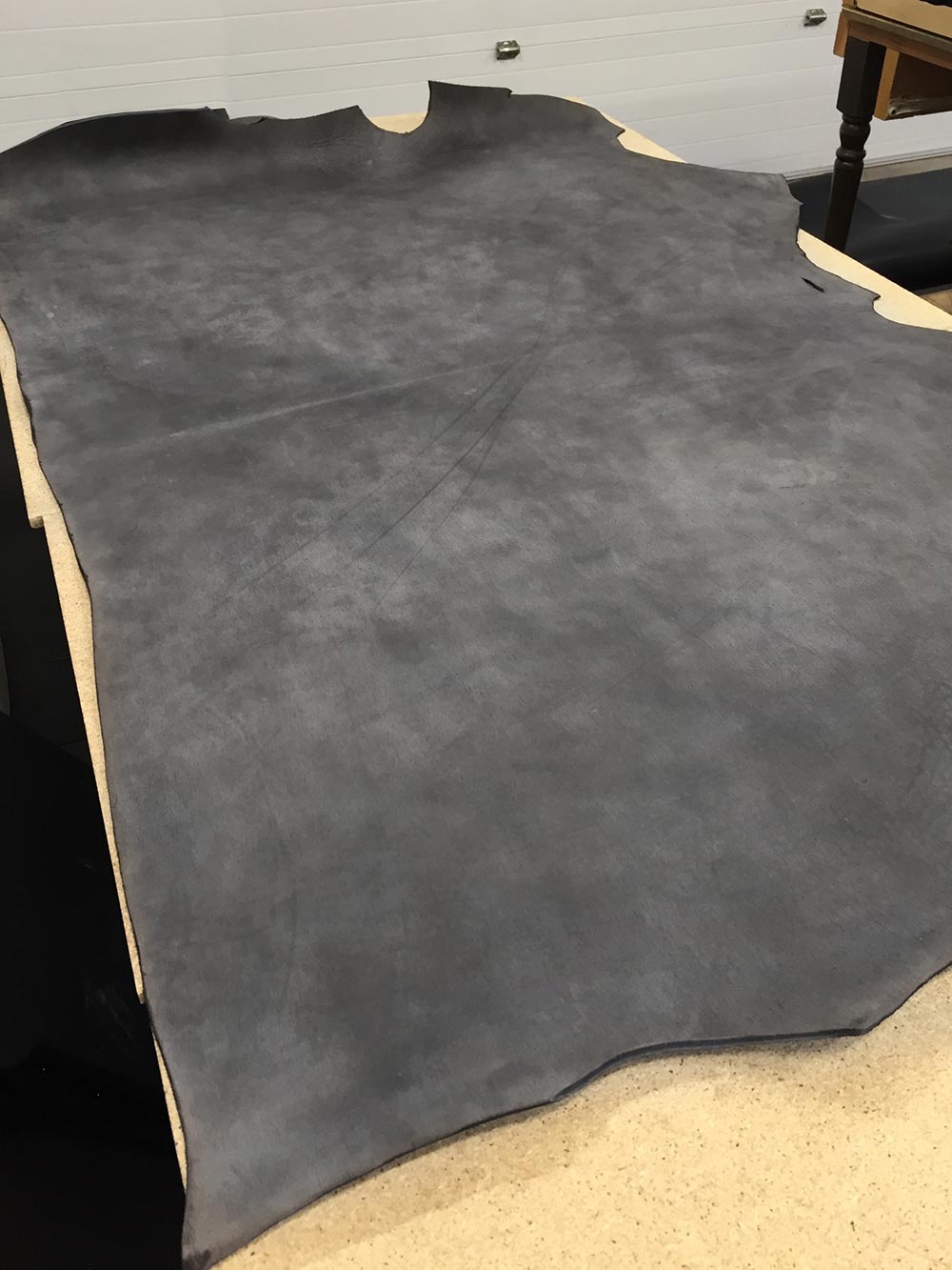 Full piece of distressed leather cowhide ready to be cut into straps to make belts. This is what a belt looks like before you purchase them.