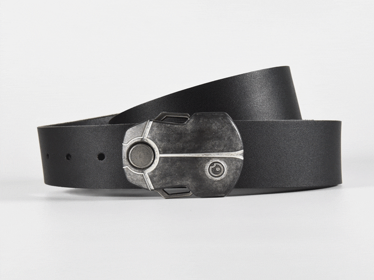 The magnetic beetle buckle opens by pushing the top wing down. The lock pivots open, releasing the buckle from the screw. The word OBSCURE is revealed on the lock's hook. Push the bottom button up to lock the buckle again.