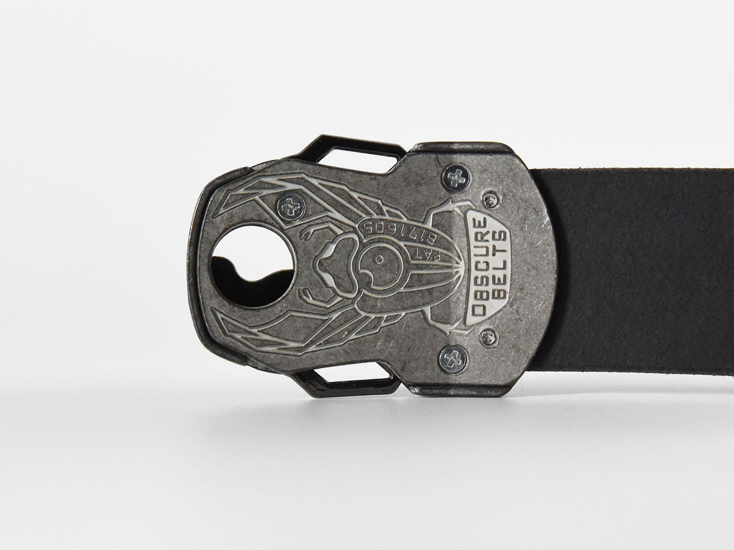 The back of the unique silver belt buckle has a recessed scarab beetle design etched in white with the words "Obscure Belts" and the patent number.